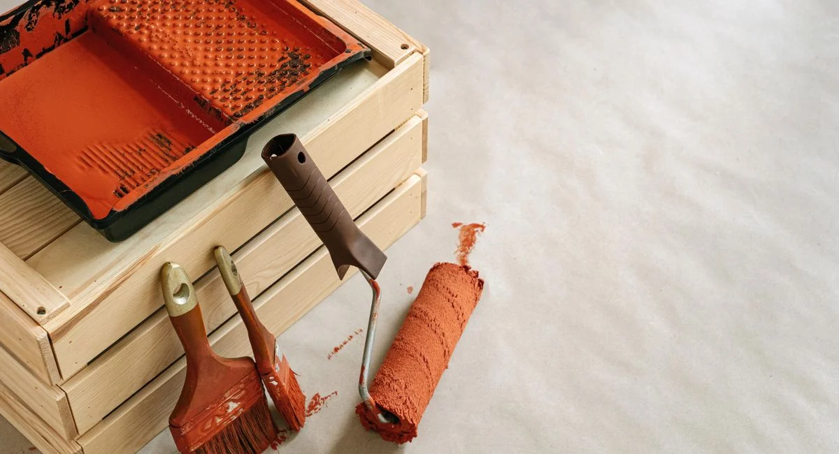 A collection of painting tools and supplies for home improvement projects, featuring brushes and a roller.